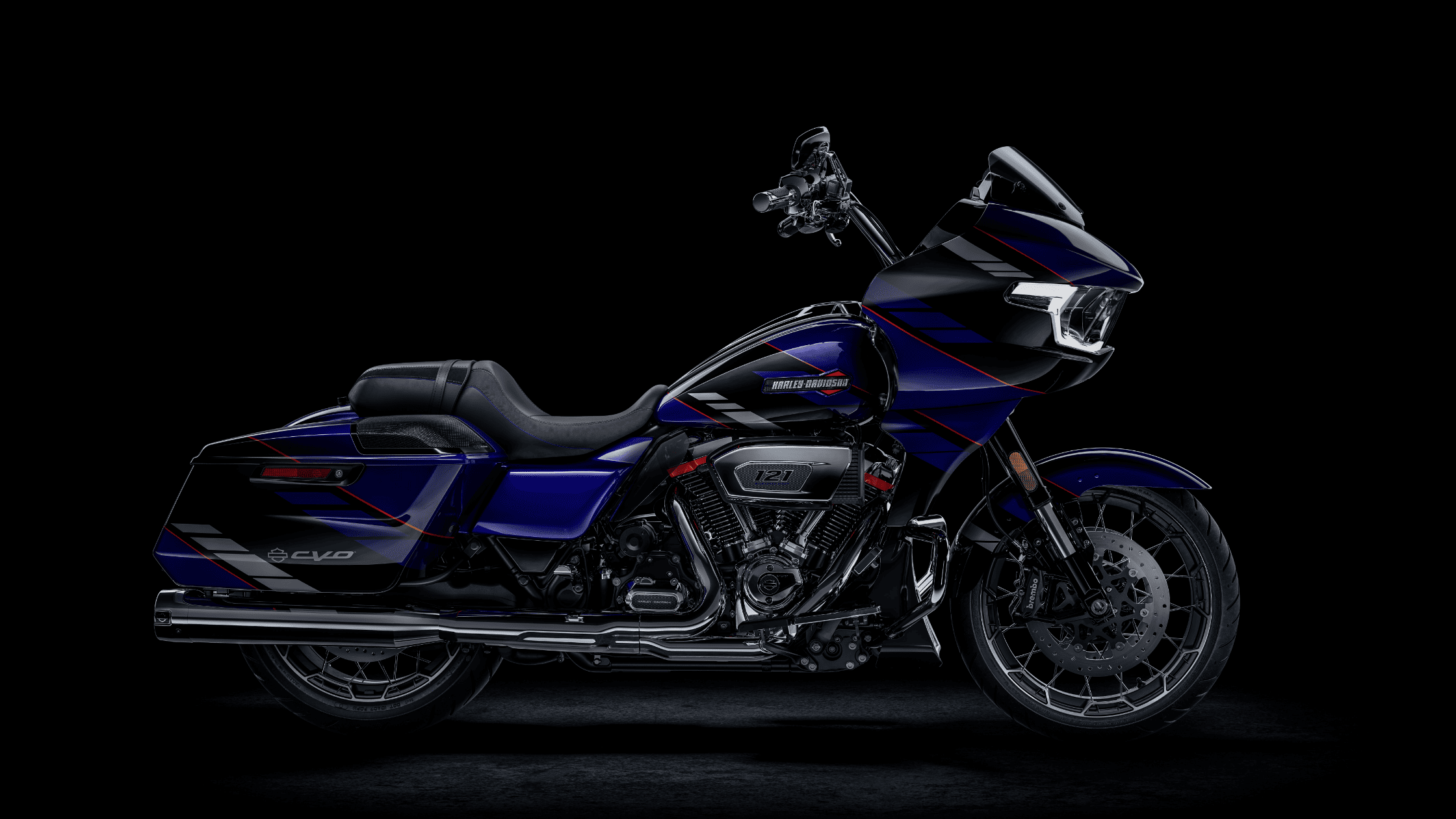 A custom-painted Harley-Davidson CVO motorcycle in black and blue with red accents, featuring a sleek fairing and saddlebags against a black background.