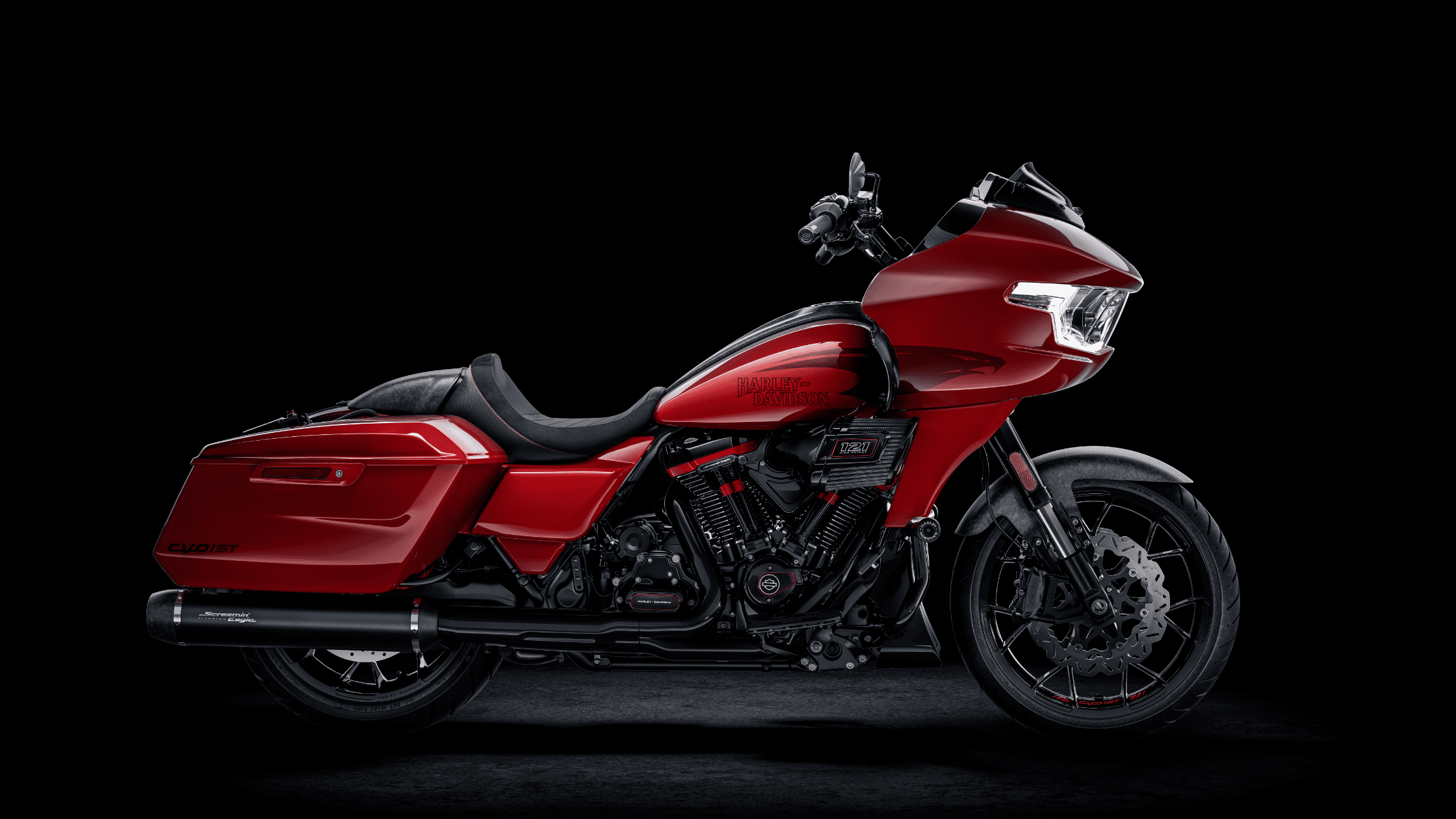 Side view of a red 2025 Harley-Davidson® CVO™ Road Glide® ST bagger motorcycle on black background.