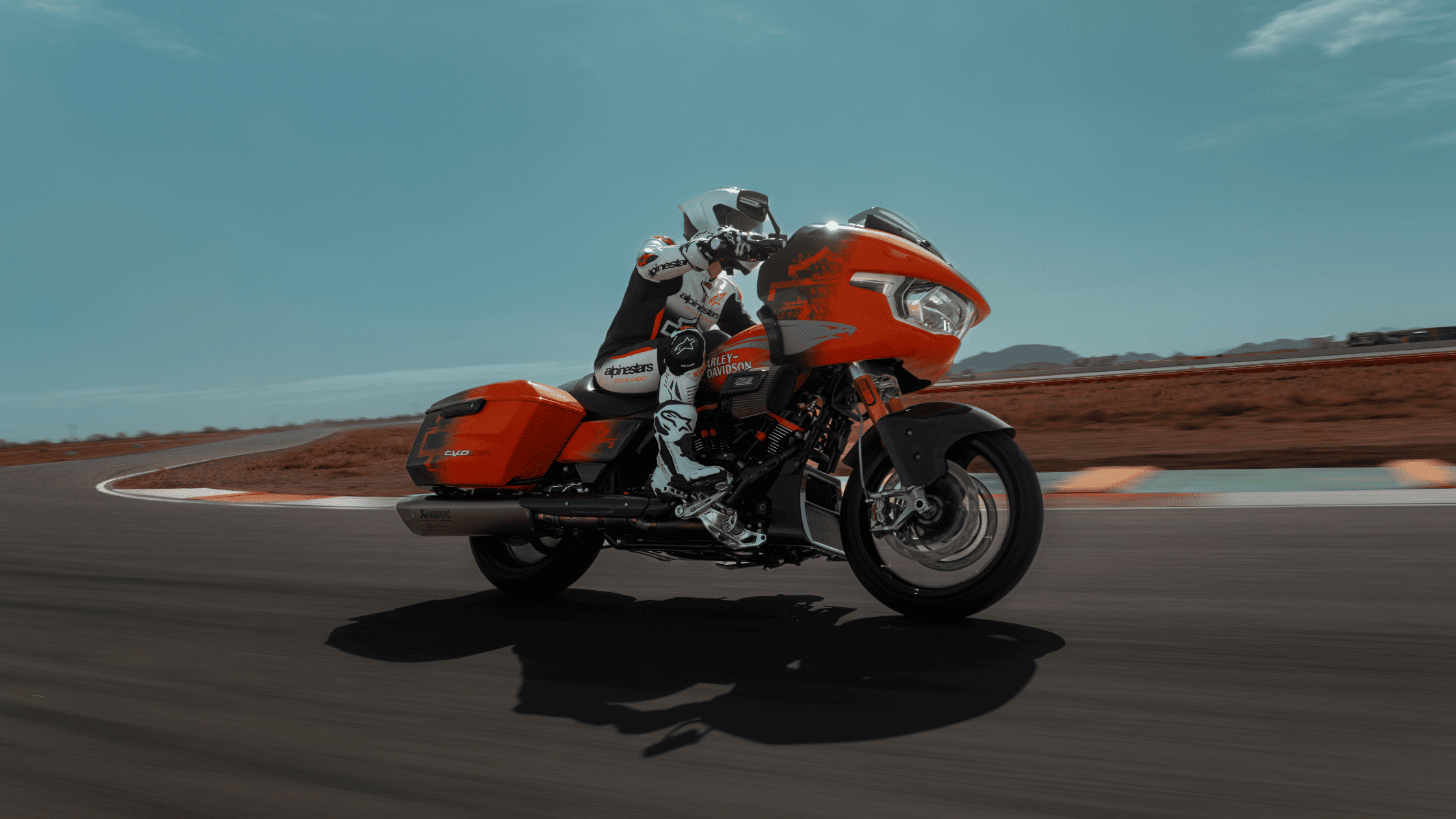 Rider racing a 2025 Harley-Davidson CVO Road Glide on a track under a clear sky.